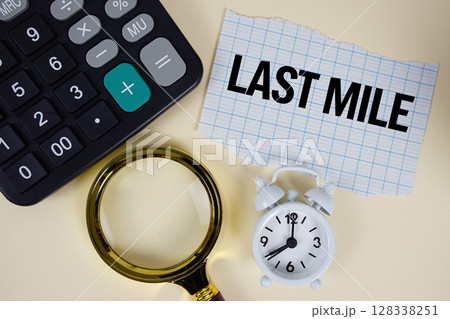 Last Mile text with alarm clock, magnifying glass anc calculator on yellow background Last Mile text with alarm clock, magnifying glass anc calculator on yellow background 128338251