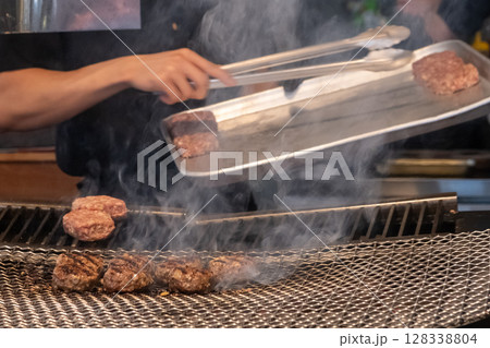Hamburg, a patty of ground beef, on the charcoal grill in the restaurant Hamburg, a patty of ground beef, on the charcoal grill in the restaurant 128338804