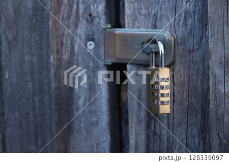 A lock with a key on a wooden door A lock with a key on a wooden door 128339097