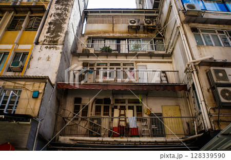 Close-up of yellow building facade with windows, pipes in Hong Kong 128339590