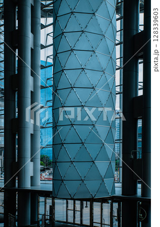 A close-up view of a large glass column inside a modern office building 128339603