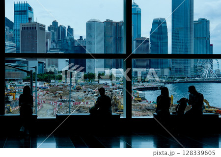 People in building view Hong Kong cityscape, seeing Ferris wheel in distance People in building view Hong Kong cityscape, seeing Ferris wheel in distance 128339605
