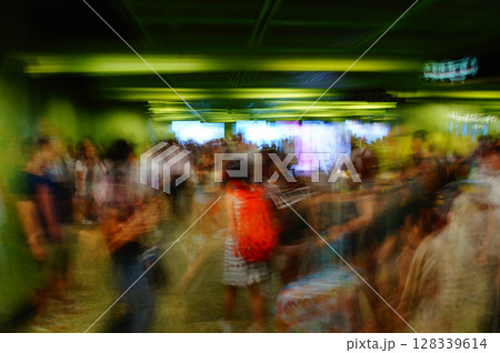 A crowd of people walking through an underground passageway with green walls with dynamic movement of shutter speed A crowd of people walking through an underground passageway with green walls with dynamic movement of shutter speed 128339614