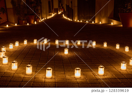 Candlelit Pathway Illuminating a Peaceful Nighttime Street With a Warm Glow Candlelit Pathway Illuminating a Peaceful Nighttime Street With a Warm Glow 128339619