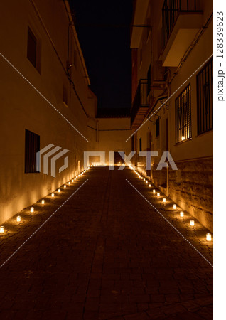 Tranquil Night Alleyway Illuminated by Aligned Candle Lights 128339623