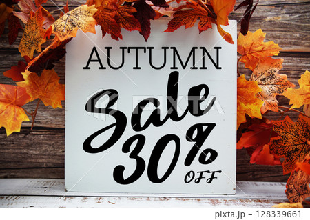 Autumn Sale 30% off text with maple leaf decoration on wooden background 128339661