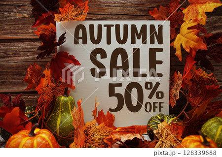Autumn Sale 50% off text with maple leaf decoration on wooden background Autumn Sale 50% off text with maple leaf decoration on wooden background 128339688