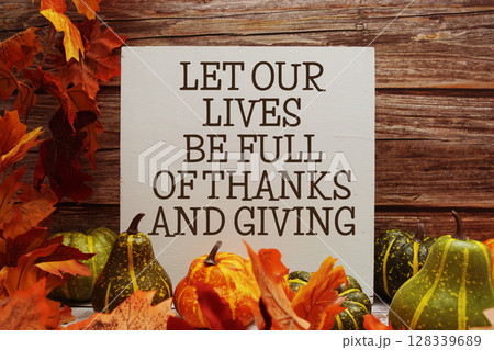 Let Our Lives Be Full Of Thanks And Giving text with maple leaf decoration on wooden background Let Our Lives Be Full Of Thanks And Giving text with maple leaf decoration on wooden background 128339689