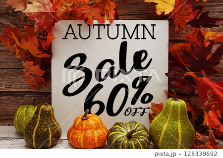 Autumn Sale 60% off text with maple leaf decoration on wooden background 128339692