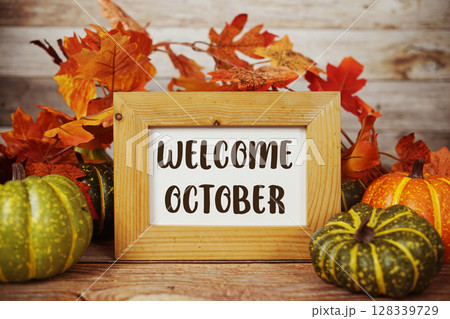 Welcome October text with maple leaf decoration on wooden background Welcome October text with maple leaf decoration on wooden background 128339729