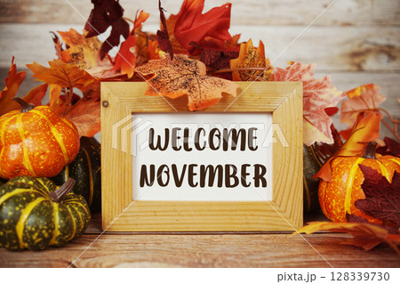 Welcome November text with maple leaf decoration on wooden background 128339730