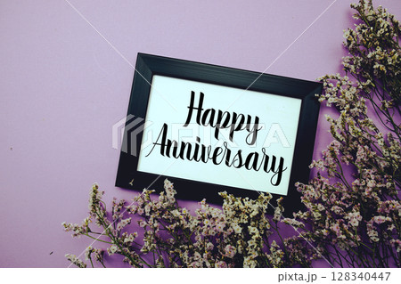 Happy Anniversary text with flowers bouquet decoration on purple background Happy Anniversary text with flowers bouquet decoration on purple background 128340447