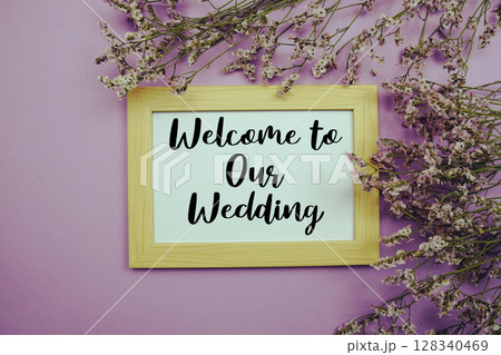 Welcome to Our Wedding text with flowers bouquet decoration on purple background 128340469
