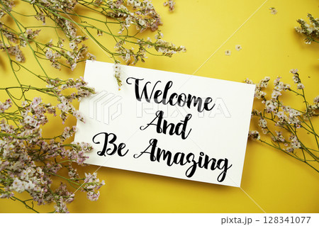 Welcome and Be Amazing text with flowers decoration on yellow background Welcome and Be Amazing text with flowers decoration on yellow background 128341077