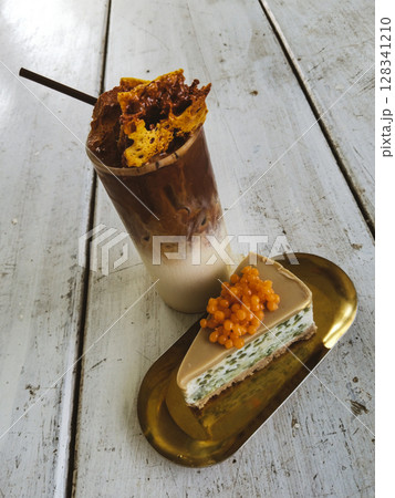Iced coffee with melted toffee sugar in a glass served with Lod Chong, Thai pandan noodles cake. 128341210