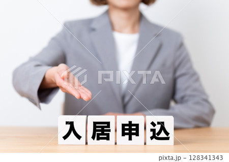 入居申込のブロックとスーツを着たミドル女性ビジネスウーマン 入居申込のブロックとスーツを着たミドル女性ビジネスウーマン 128341343