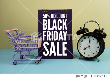 Black Friday Sale Promotion and Marketing wiht mini trolley shopping cart and alarm clock on blue and yellow background 128342519