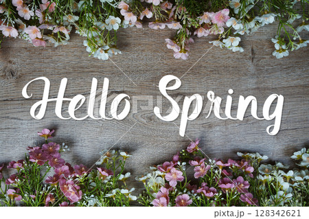 Hello Spring text message with flowers decoration on wooden background 128342621