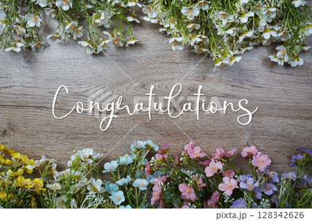 Congratulations text message with flowers decoration on wooden background Congratulations text message with flowers decoration on wooden background 128342626
