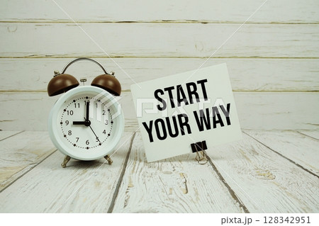 Start Your Way text on paper card with alarm clock on wooden background 128342951