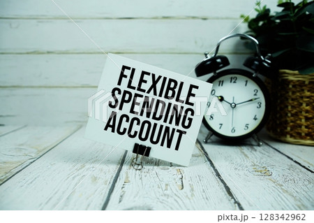 Flexible Spending Account text on paper card with alarm clock on wooden background Flexible Spending Account text on paper card with alarm clock on wooden background 128342962