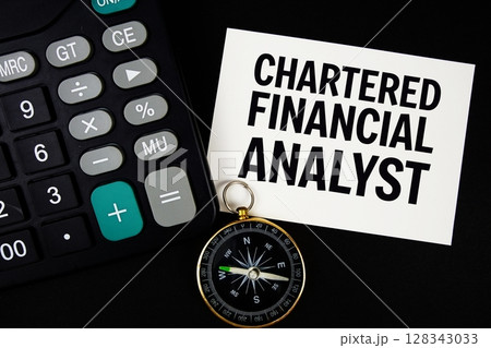 Chartered Financial Analyst text with compass and calculator on black background 128343033