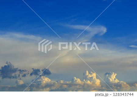 夕日を受けて薄いオレンジ色に染まる雲 128343744