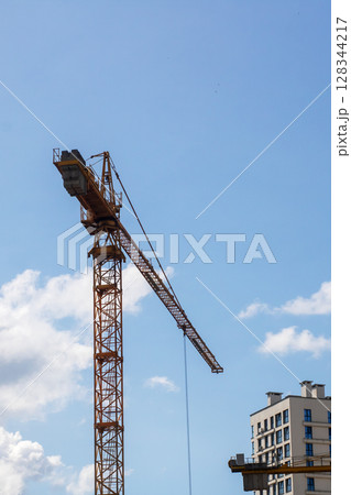 A large construction crane is currently being used to lift a building 128344217