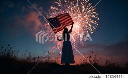 Woman holding paper US flag standing on hill under fireworks at night Woman holding paper US flag standing on hill under fireworks at night 128344354