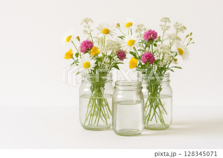 Bouquets of wildflowers in jars of water. 128345071