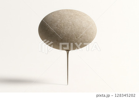 A large rock balances on a sharp metal spike. 128345202