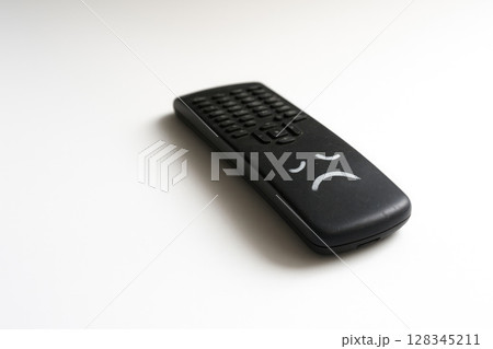 A remote control with a painted sad face. Space for text. 128345211