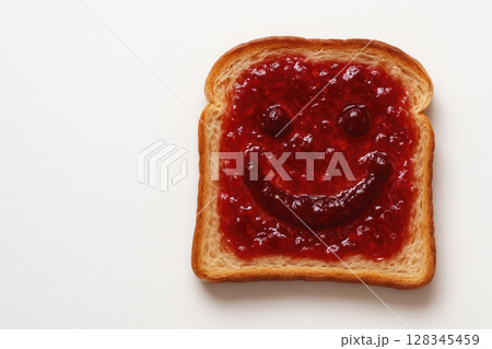 Toast with jam in the form of a smiling face. Space for text. 128345459
