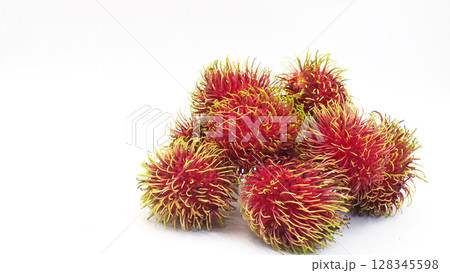 Close-up of ripe rambutan fruits with vibrant red skin and soft green spines, isolated on a white background. Ideal for use in tropical fruit promotions Close-up of ripe rambutan fruits with vibrant red skin and soft green spines, isolated on a white background. Ideal for use in tropical fruit promotions 128345598