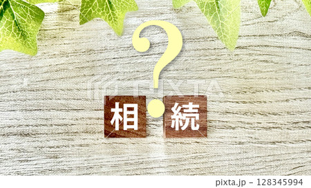木の立方体に相続の文字とクエスチョンマーク_白板背景 木の立方体に相続の文字とクエスチョンマーク_白板背景 128345994