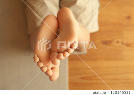 夏の室内で裸足で過ごす小学生の足 128346531