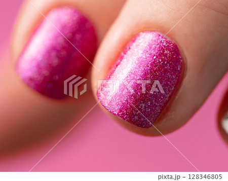 Female hand with pink manicure. Close up of short fingernail with pink holographic nail polish gel lacquer. Aesthetic visual of red violet holo manicure Female hand with pink manicure. Close up of short fingernail with pink holographic nail polish gel lacquer. Aesthetic visual of red violet holo manicure 128346805