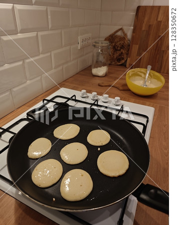 Cooking fluffy pancakes in a cozy kitchen during a weekend brunch with friends and family enjoying the warmth of home Cooking fluffy pancakes in a cozy kitchen during a weekend brunch with friends and family enjoying the warmth of home 128350672