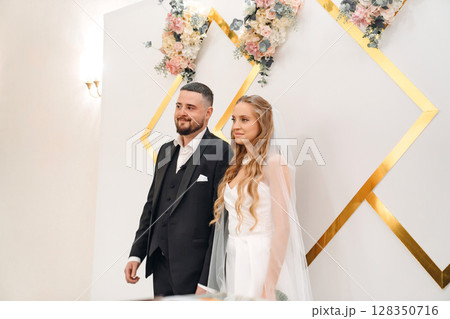 The bride and groom at the ceremony in the Wedding Palace.  128350716