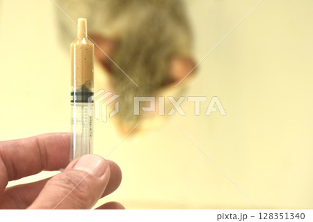 close up hand holding medical liquid food in syringe for feeding cat to treatment  128351340