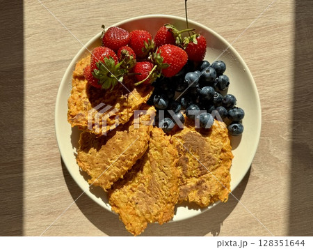 pumpkin fritters with fresh blueberries and strawberries for breakfast. High quality photo 128351644