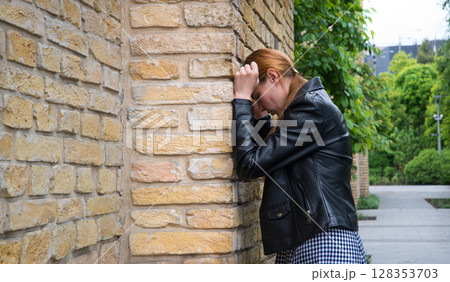 Sad woman at the wall Sad woman at the wall 128353703
