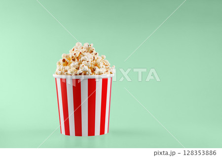 Classic red striped popcorn cardboard cup on Green background 128353886
