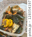Close-up of a flavorful seafood boil featuring crab, mussels, shrimp, and corn on the cob. 128354197