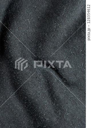 Macro texture of black fabric with lots of pilling and damage on the surface. 128354612