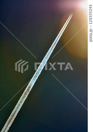 太陽へ向かう飛行機雲と光芒 128355243
