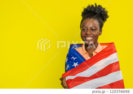 Black young woman waving and wrapping in American USA flag, celebrating, human rights and freedoms 128356698