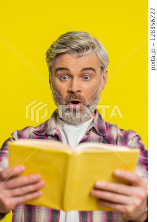 Mature man opening book, amazed face, sudden revelation, instant interest surprising story vibe 128356727