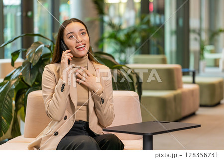 Happy surprised business woman in pleasant conversation phone call good news enjoying talking gossip 128356731