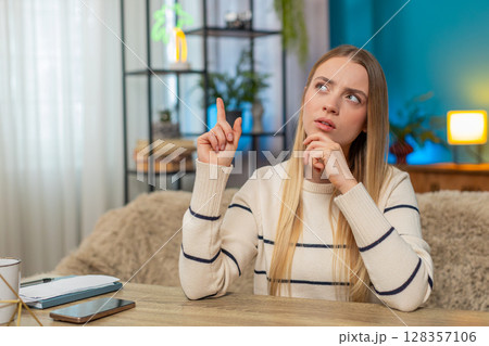 Caucasian woman deep in thought at home, hand on chin, looking aside, pondering a solution decisions 128357106